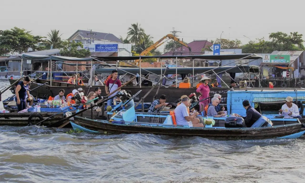Experience the vibrant life of Cai Rang Floating Market in the heart of the Mekong Delta. This authentic scene in Can Tho showcases local vendors and travelers enjoying breakfast on traditional wooden boats, surrounded by bustling trade, fresh tropical fruits, and the dynamic river culture that defines southern Vietnam. A must-visit destination for those seeking an immersive cultural and culinary experience.